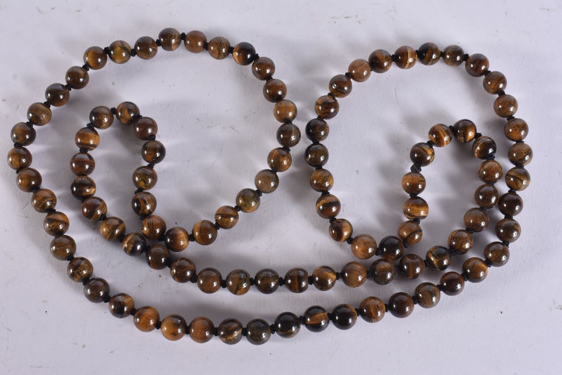 A CHINESE TIGERS EYE NECKLACE. 88 cm long.: A CHINESE TIGERS EYE NECKLACE. 88 cm long.