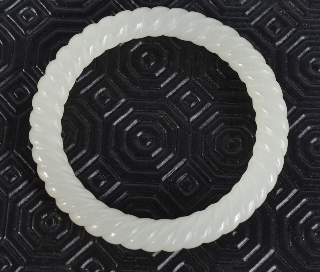 A CHINESE WHITE JADE TWIST BANGLE. 8 cm wide. (1 of 3)