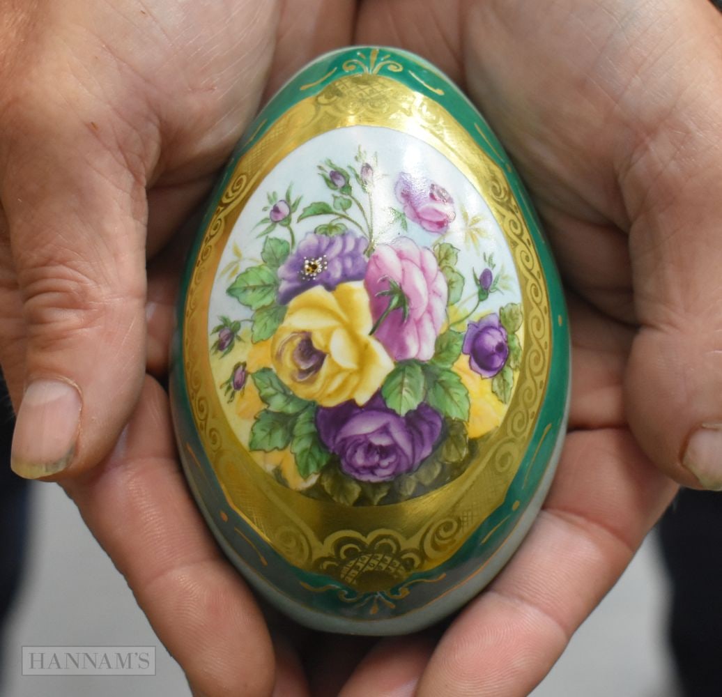 A RUSSIAN PORCELAIN PAINTED EASTER EGG decorated with flowers within a gilded cartouche. 10 cm x 7 c (1 of 4)