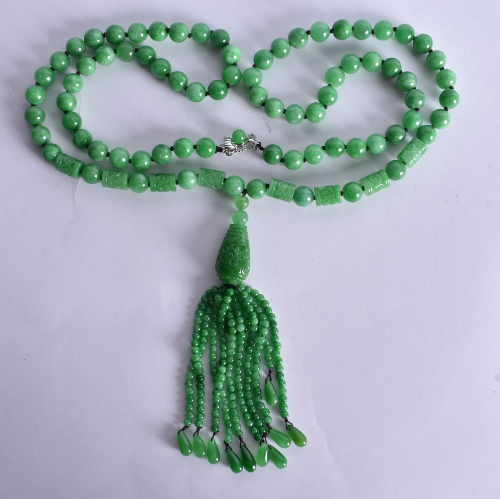 A green Jade Bead Necklace with a Tassel Pendant and 14 Carat White Gold Clasp. Stamped 14K 585. Le: A green Jade Bead Necklace with a Tassel Pendant and 14 Carat White Gold Clasp. Stamped 14K 585. Length 90cm, weight 170.5g
