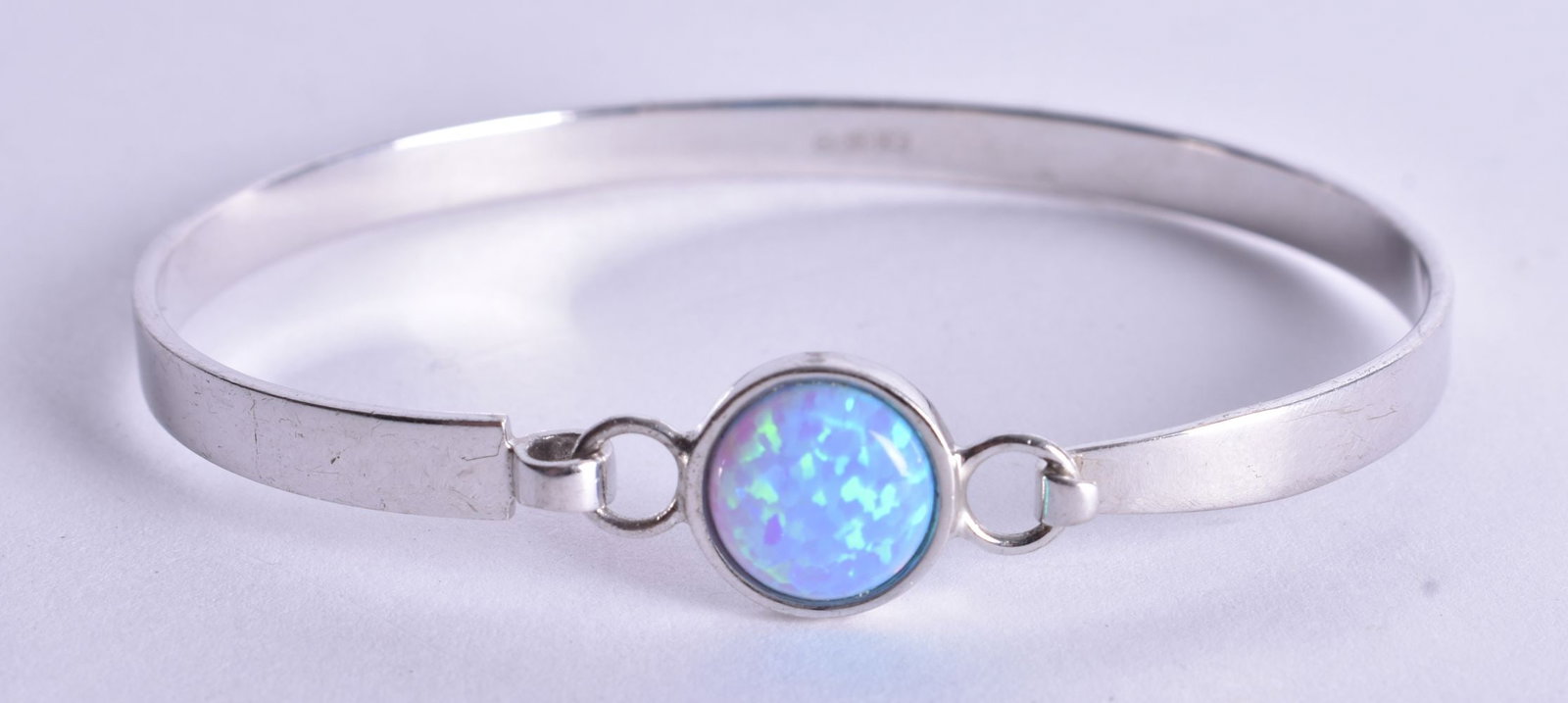 A Silver Bracelet set with an Opal. Stamped 925. 5.1cm x 6.3cm, weight 12g: A Silver Bracelet set with an Opal. Stamped 925. 5.1cm x 6.3cm, weight 12g
