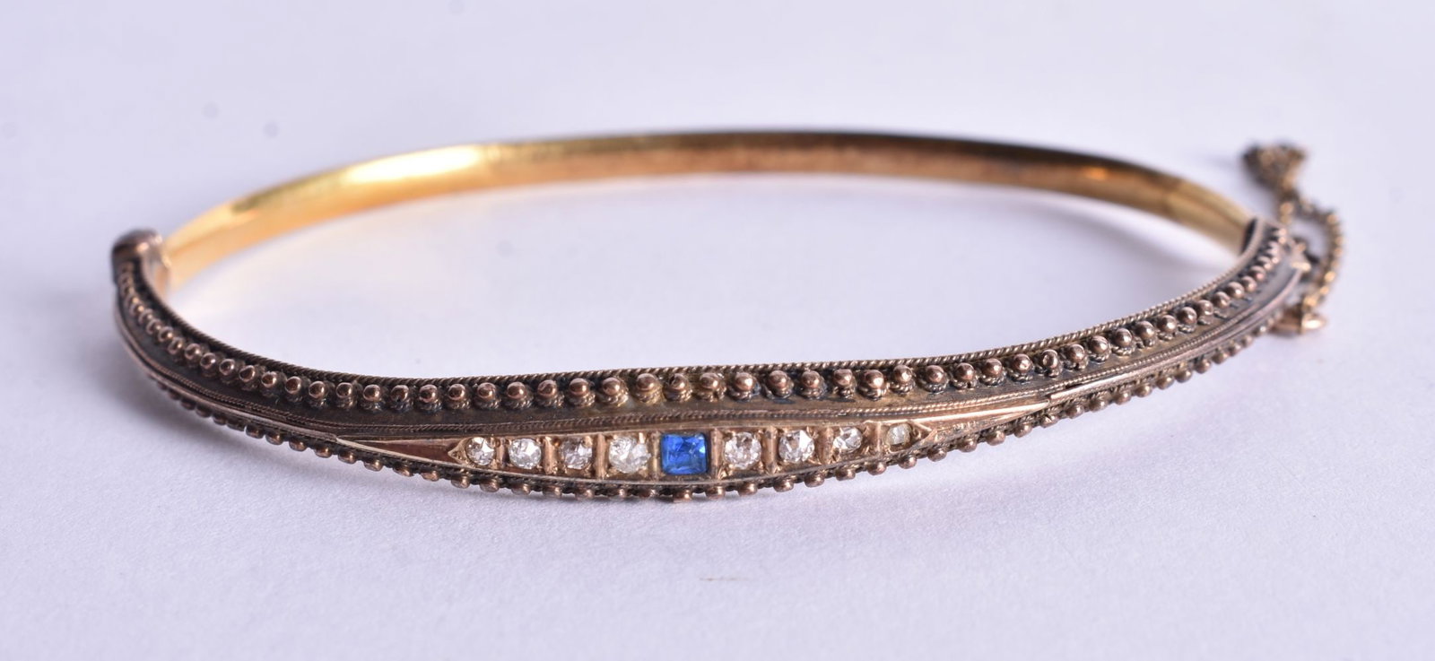 A Victorian 15 Carat Gold, Diamond and Sapphire Bangle. Stamped 15CT, Internal 5.9cm x 4.5cm, weigh: A Victorian 15 Carat Gold, Diamond and Sapphire Bangle. Stamped 15CT, Internal 5.9cm x 4.5cm, weight 7g