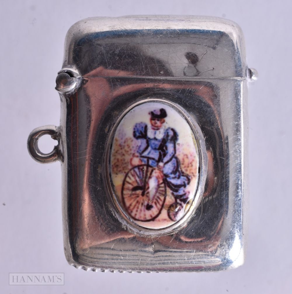 A Silver Fob Vesta with an Enamel Cabochon of a Lady Riding a Bicycle. Hallmarked Birmingham 1907,: A Silver Fob Vesta with an Enamel Cabochon of a Lady Riding a Bicycle. Hallmarked Birmingham 1907, 3.8cm x 2.8cm x 1.2cm, weight 15g