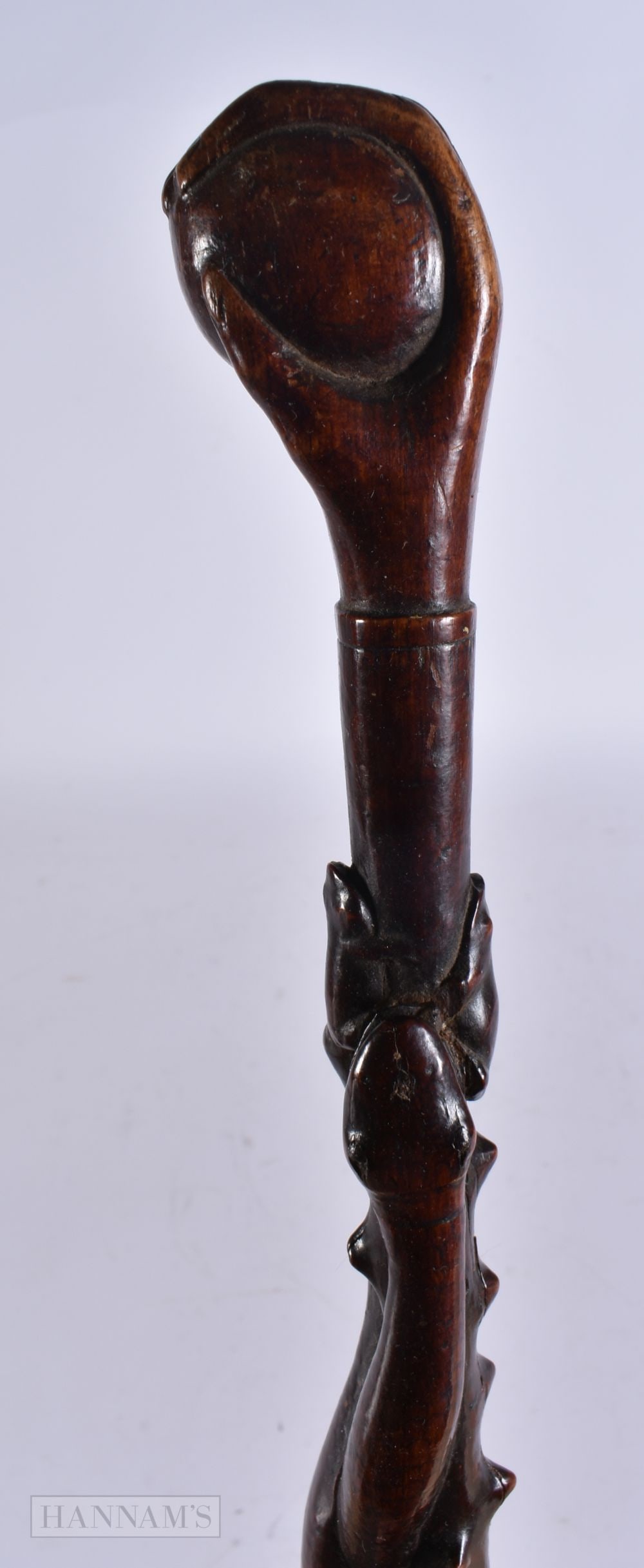 AN ANTIQUE FOLK ART WOOD SNAKE SWAGGER STICK with fist terminal. 65 cm long.: AN ANTIQUE FOLK ART WOOD SNAKE SWAGGER STICK with fist terminal. 65 cm long.