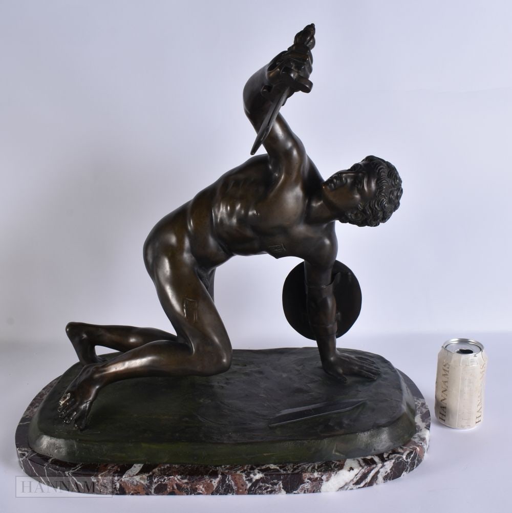A RARE AND LARGE EARLY 20TH CENTURY GRAND TOUR BRONZE FIGURE OF A FALLEN WARRIOR modelled upon a mar: A RARE AND LARGE EARLY 20TH CENTURY GRAND TOUR BRONZE FIGURE OF A FALLEN WARRIOR modelled upon a marble base. 52 cm x 46cm