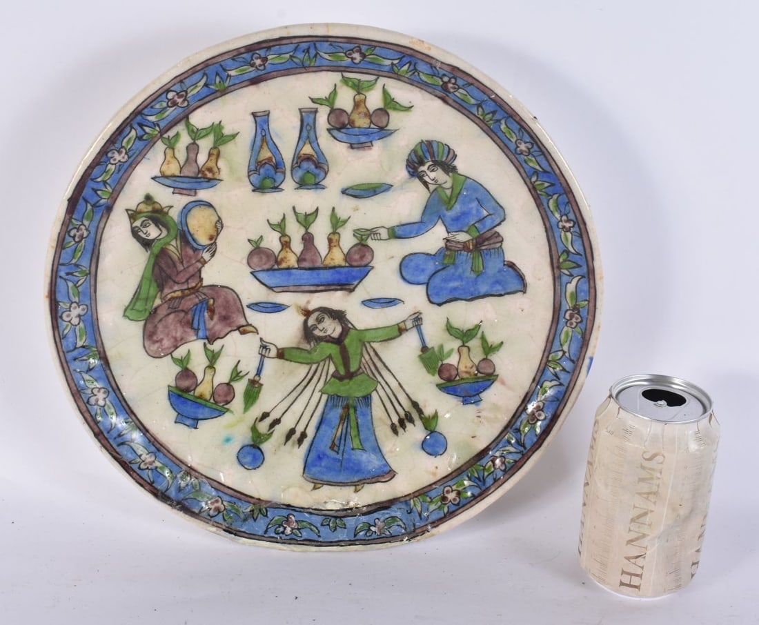 A 19TH CENTURY PERSIAN MIDDLE EASTERN QAJAR POTTERY DISH painted with figures. 30cm wide.: A 19TH CENTURY PERSIAN MIDDLE EASTERN QAJAR POTTERY DISH painted with figures. 30cm wide.