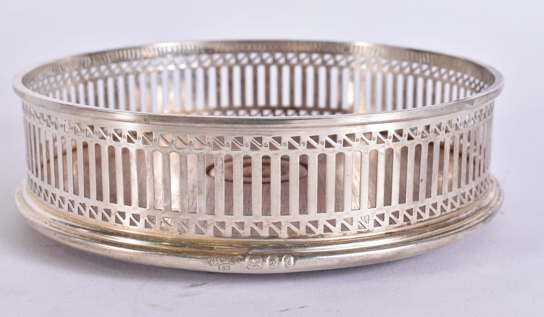 A SILVER BOTTLE COASTER. 12 cm wide. (1 of 5)