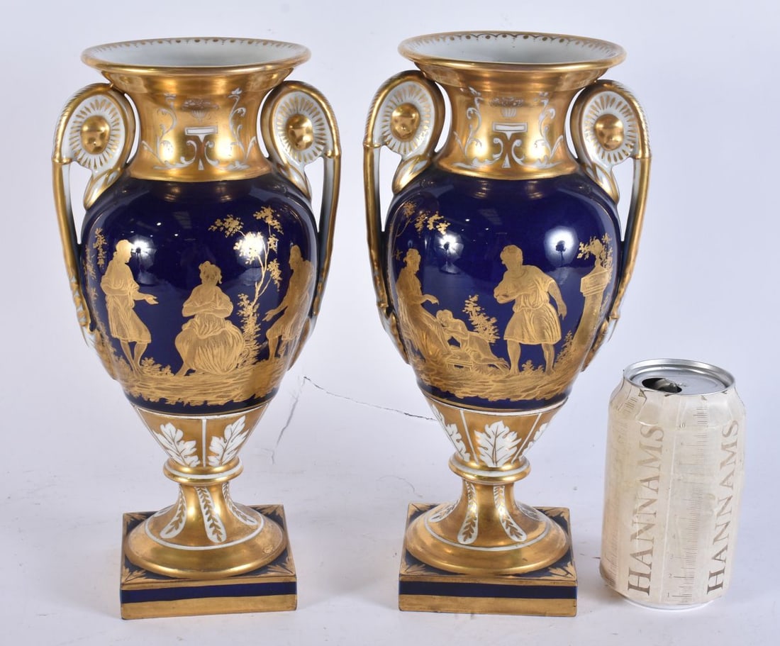 A FINE PAIR OF 19TH CENTURY FRENCH TWIN HANDLED PORCELAIN VASES beautifully painted with gilded figu: A FINE PAIR OF 19TH CENTURY FRENCH TWIN HANDLED PORCELAIN VASES beautifully painted with gilded figures on a rich cobalt ground. 27cm x 10 cm.