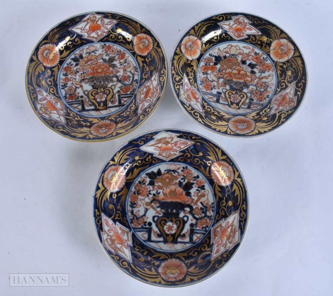 THREE 17TH/18TH CENTURY JAPANESE GENROKU PERIOD IMARI PLATES painted with urns of flowers. 21.5 cm w (1 of 5)