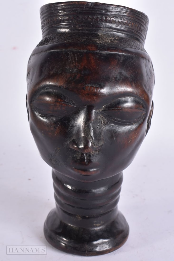 AN AFRICAN TRIBAL CARVED WOOD CUP. 19 cm high.: AN AFRICAN TRIBAL CARVED WOOD CUP. 19 cm high.