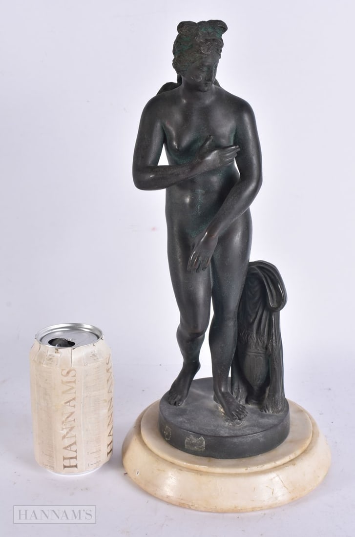 A 19TH CENTURY GRAND TOUR BRONZE FIGURE OF THE BATHING VENUS modelled upon a marble base. 36 cm high: A 19TH CENTURY GRAND TOUR BRONZE FIGURE OF THE BATHING VENUS modelled upon a marble base. 36 cm high.