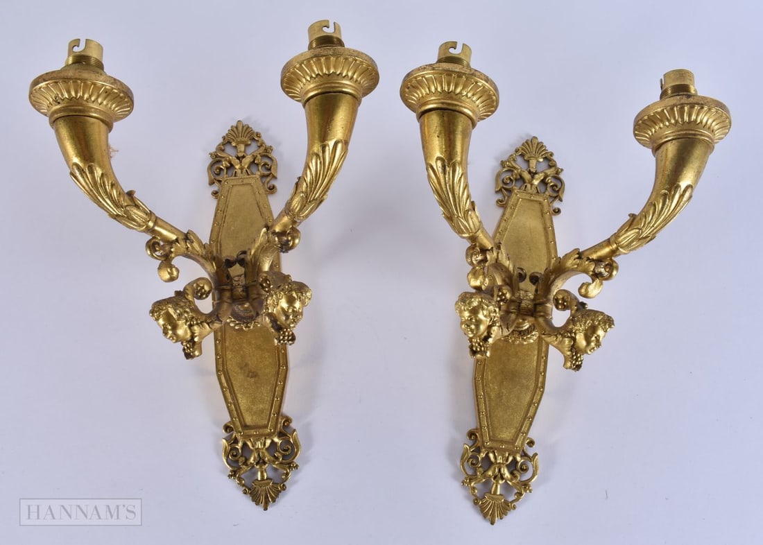 A PAIR OF 19TH CENTURY FRENCH GILT BRONZE WALL SCONCES formed with mask heads. 28 cm x 14 cm.: A PAIR OF 19TH CENTURY FRENCH GILT BRONZE WALL SCONCES formed with mask heads. 28 cm x 14 cm.