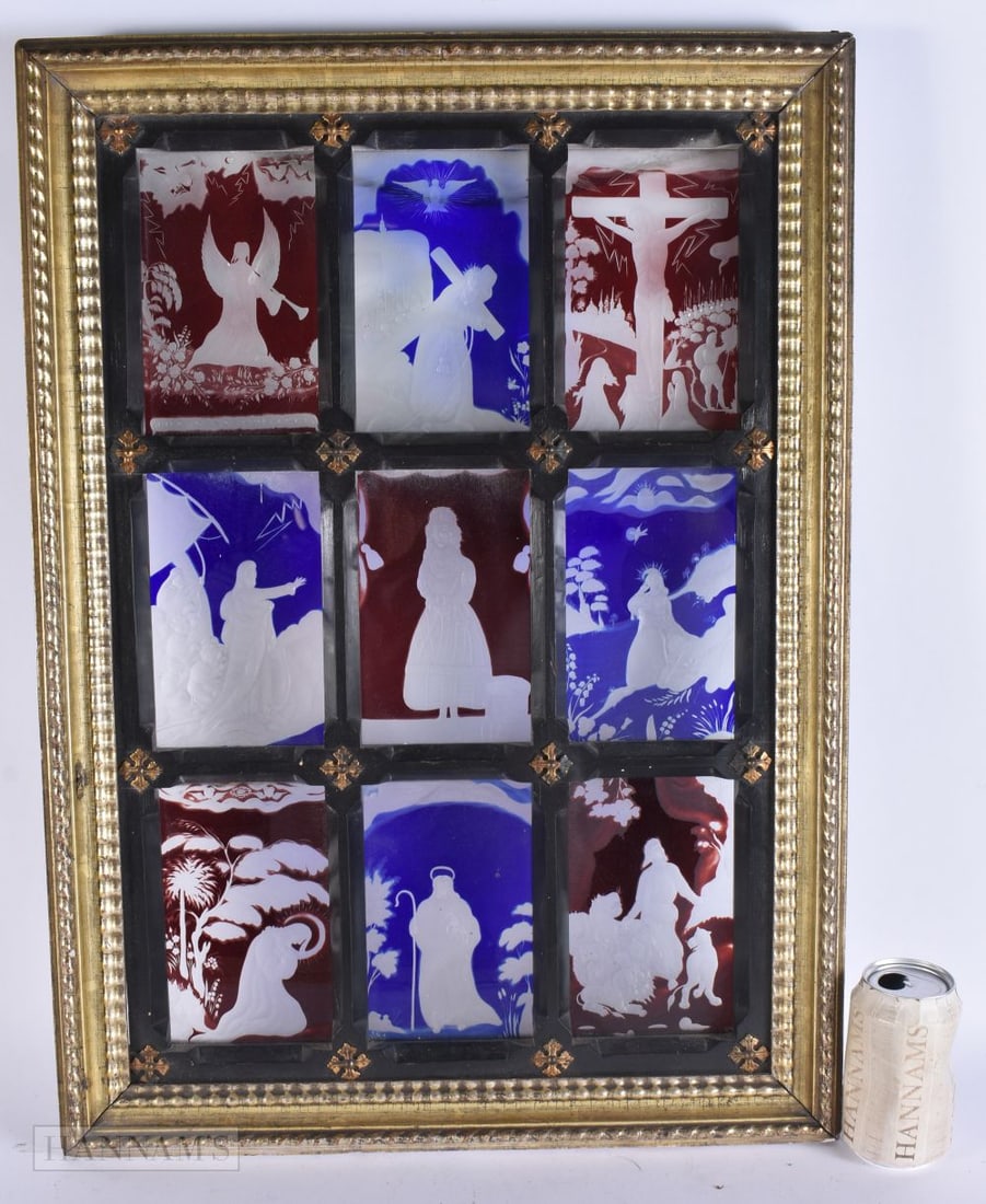 A 19TH CENTURY BOHEMIAN COLOURED GLASS RELIGIOUS PANEL contained within a frame embellished with mot: A 19TH CENTURY BOHEMIAN COLOURED GLASS RELIGIOUS PANEL contained within a frame embellished with motifs. 68 cm x 48 cm.