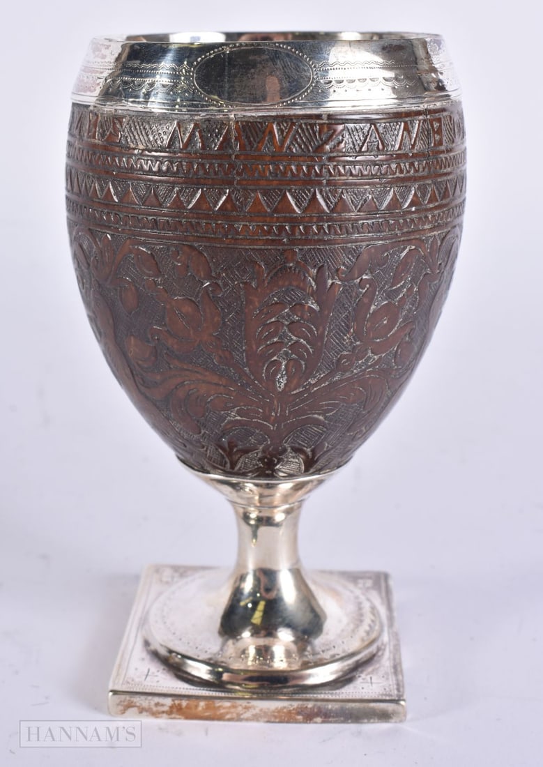 AN 18TH CENTURY SILVER MOUNTED COLONIAL COCONUT CUP upon a square pedestal base. 12.5 cm high. (1 of 5)