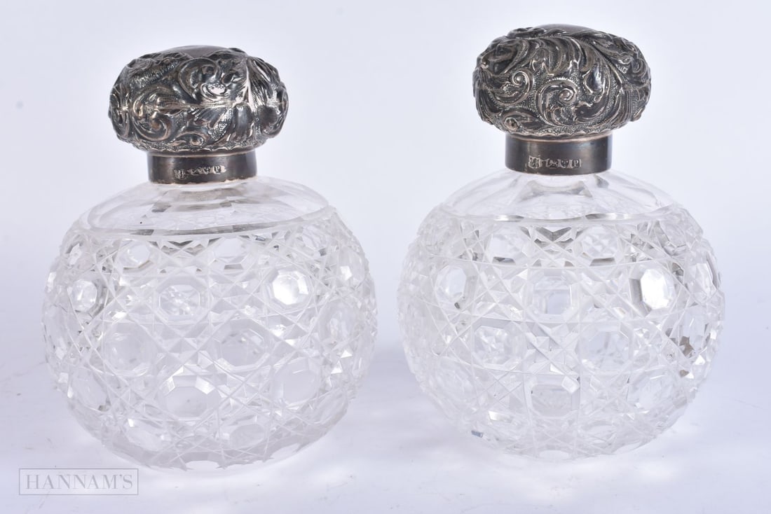 A PAIR OF VICTORIAN SILVER MOUNTED CUT GLASS SCENT BOTTLES. 15 cm x 10 cm. (1 of 4)