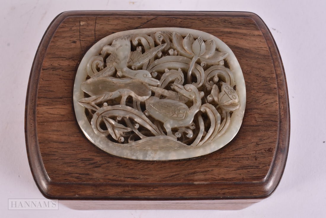 A 16TH/17TH CENTURY CHINESE RETICULATED JADE PLAQUE Ming, contained within a hardwood box, possibly: A 16TH/17TH CENTURY CHINESE RETICULATED JADE PLAQUE Ming, contained within a hardwood box, possibly huanghuali. 12 cm x 10 cm, jade 8.5 cm x 7 cm.