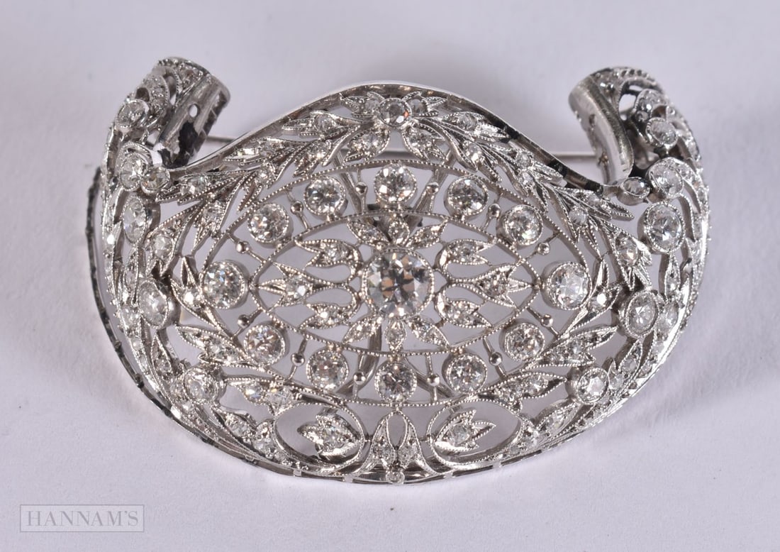AN EDWARDIAN NEO CLASSICAL PLATINUM AND DIAMOND BROOCH. 13.7 grams. 4.25 cm x 3 cm, largest diamond (1 of 3)