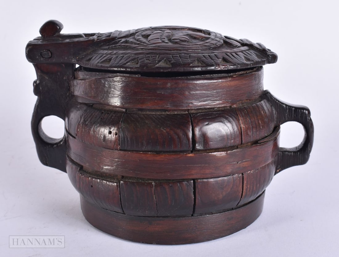 Treen - a 19th century Icelandic pine askur food box, of staved construction, hinged cover carved wi: Treen - a 19th century Icelandic pine askur food box, of staved construction, hinged cover carved with scrolls, pierced lug handles. 17 cm wide. Note: For a similar example see Peasant Art in Sweden, 