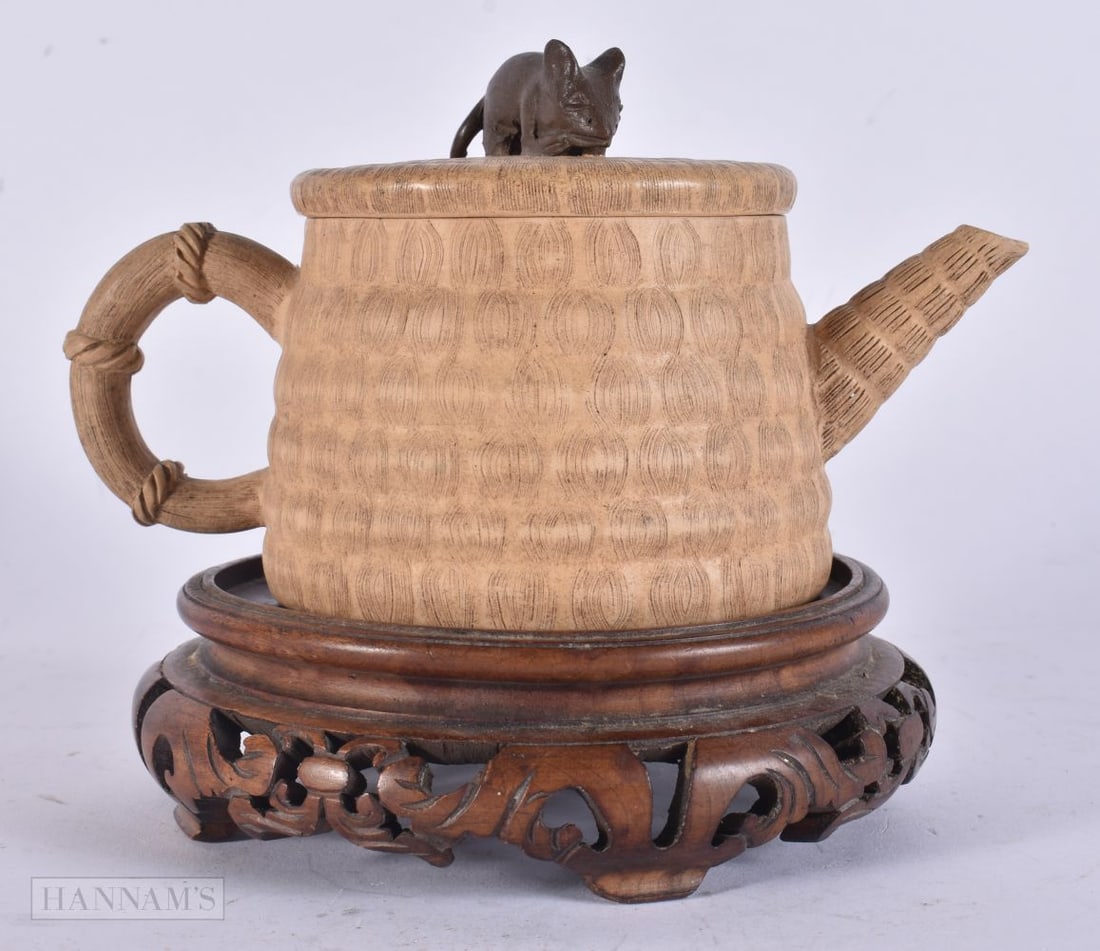 A CHINESE YIXING POTTERY TEAPOT AND COVER upon an associated stand. 15 cm wide. (1 of 5)