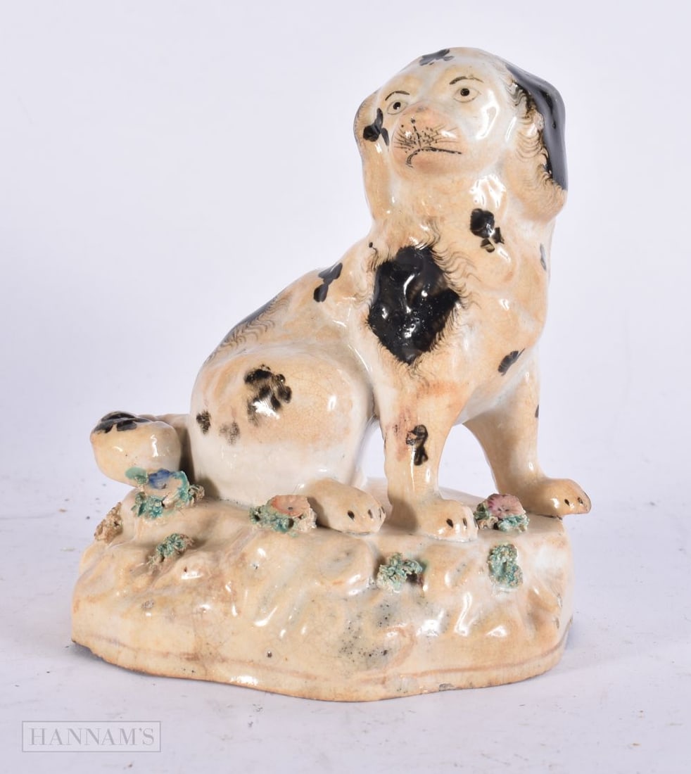A 19TH CENTURY STAFFORDSHIRE BLACK AND WHITE SPANIEL encrusted with flowers. 14 cm x 9 cm. (1 of 3)
