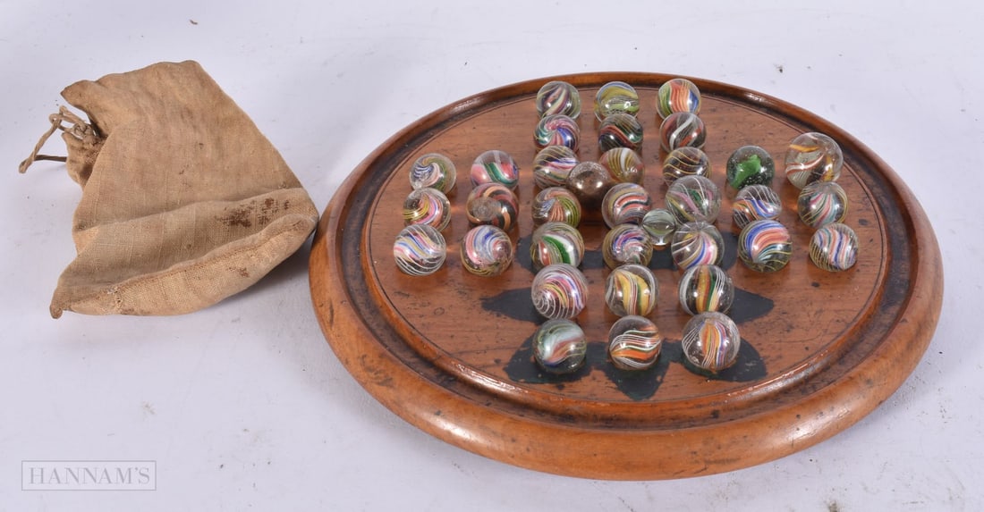 A SET OF ANTIQUE SOLITAIRE MARBLES ON STAND. 18.5 cm wide. (1 of 2)