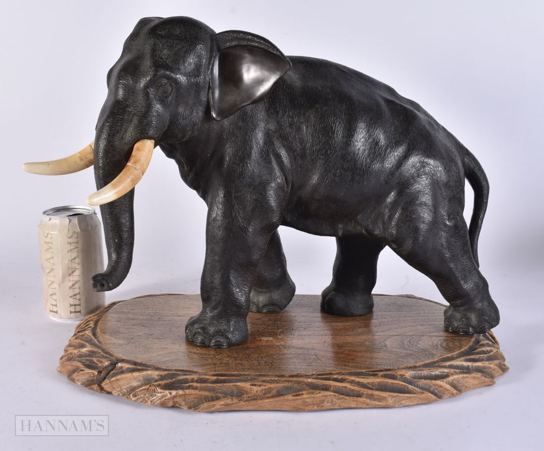 A 19TH CENTURY JAPANESE MEIJI PERIOD BRONZE ELEPHANT OKIMONO modelled upon a wooden base. Elephant 3 (1 of 3)