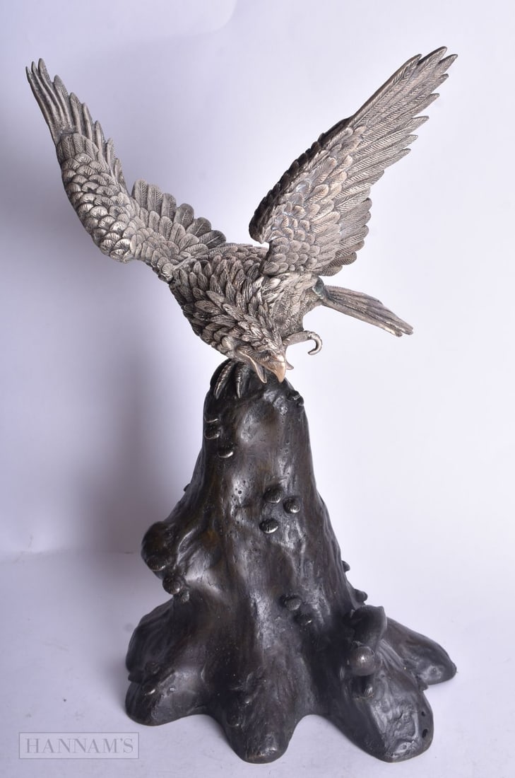A JAPANESE WHITE METAL OKIMONO OF A HAWK ON A BRONZE NATURALISTIC BASE. 30 x 18 cm.: A JAPANESE WHITE METAL OKIMONO OF A HAWK ON A BRONZE NATURALISTIC BASE. 30 x 18 cm.