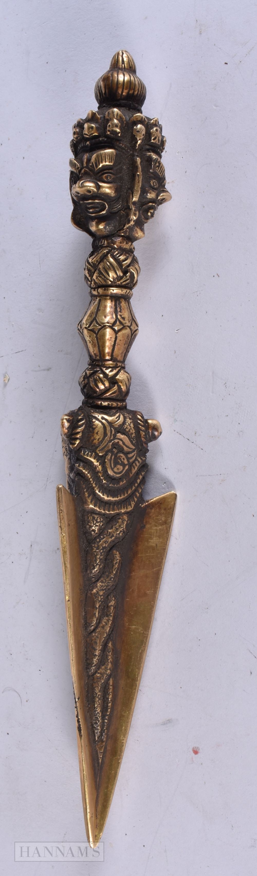 A 19TH CENTURY TIBETAN BRONZE PHURBA formed with mask heads and beasts. 20.5 cm long.: A 19TH CENTURY TIBETAN BRONZE PHURBA formed with mask heads and beasts. 20.5 cm long.