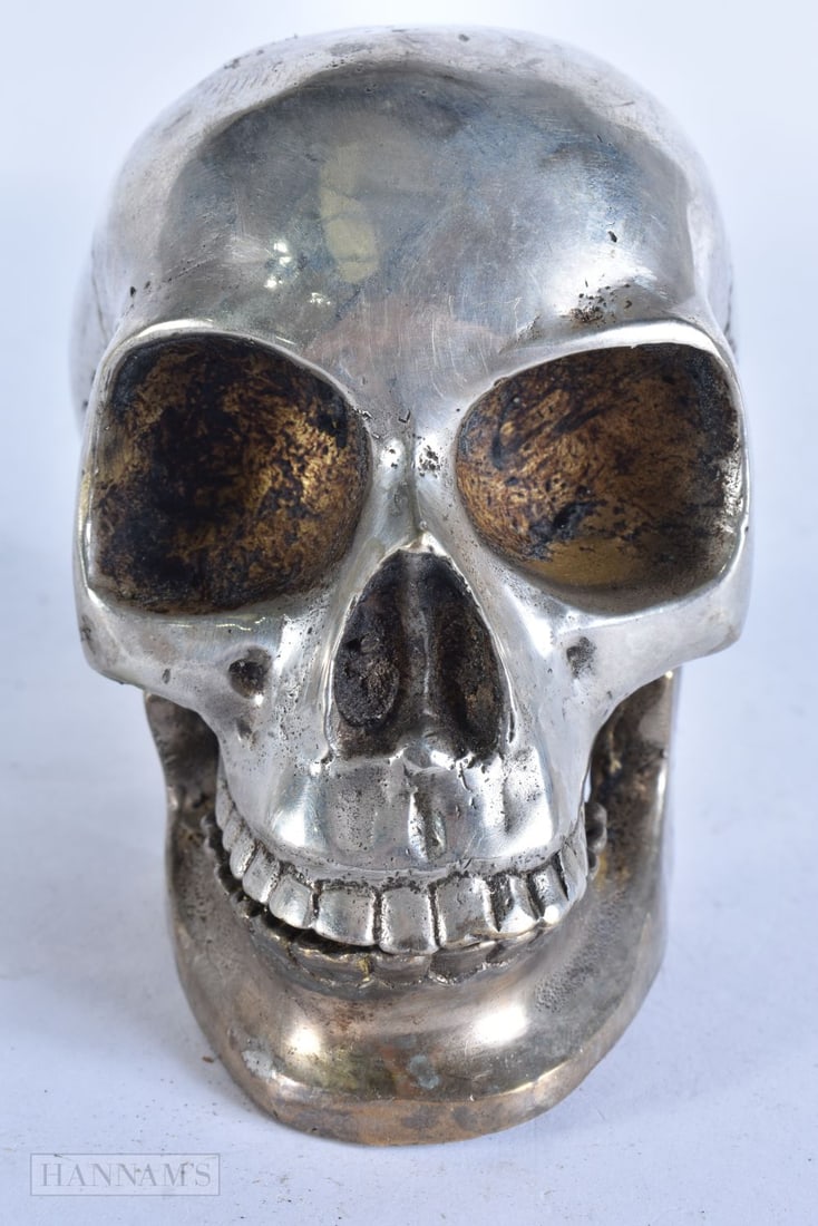 A SILVER PLATED SKULL. 12 cm wide. (1 of 4)