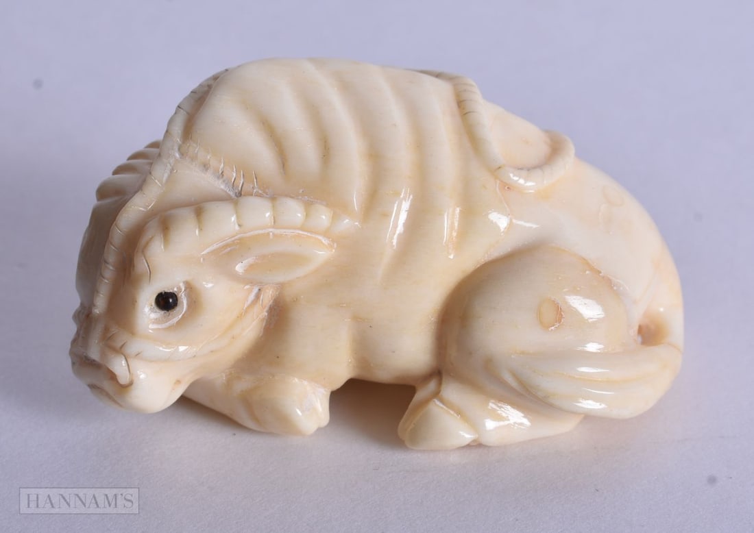 A JAPANESE BONE BULL NETSUKE. 4.75 cm x 2.75 cm.: A JAPANESE BONE BULL NETSUKE. 4.75 cm x 2.75 cm.