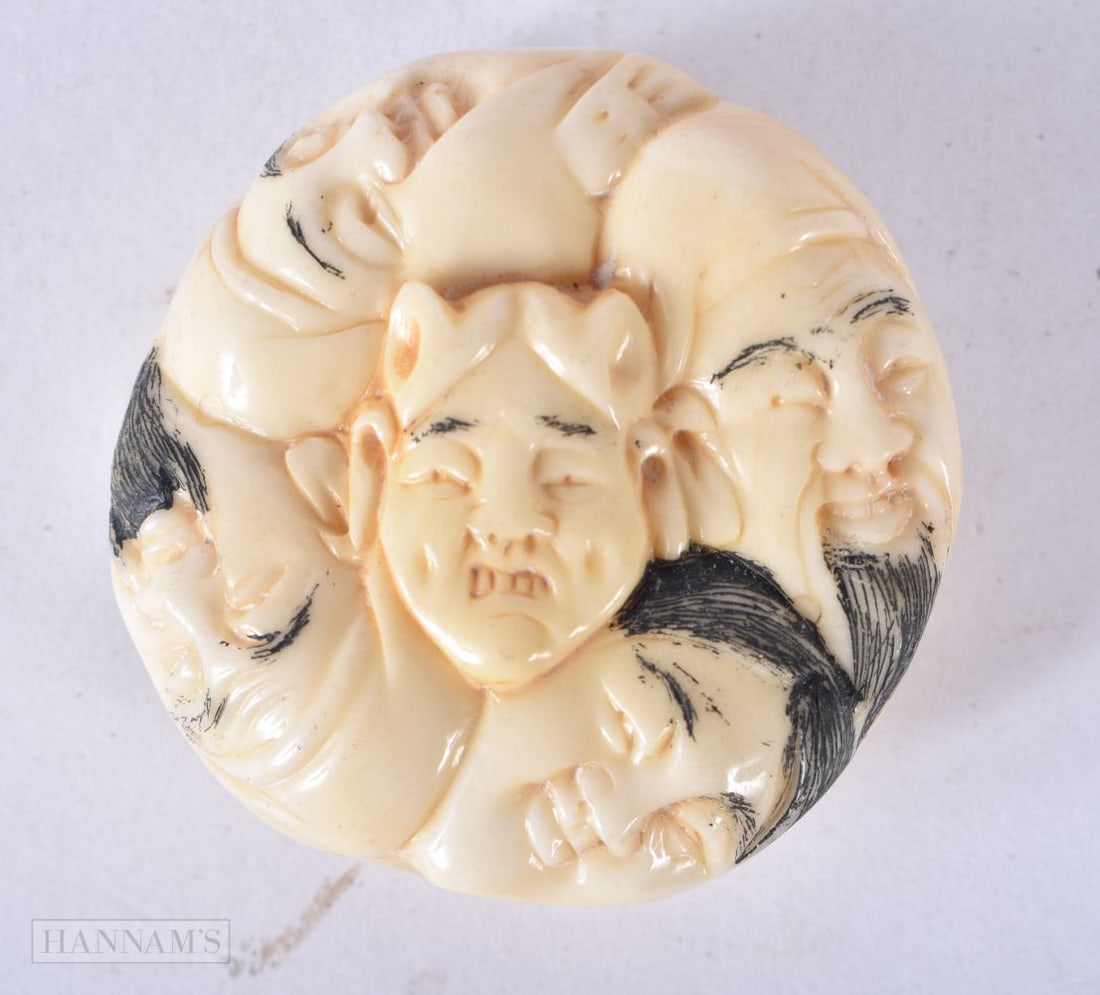 A JAPANESE BONE FACES NETSUKE. 4 cm wide.: A JAPANESE BONE FACES NETSUKE. 4 cm wide.