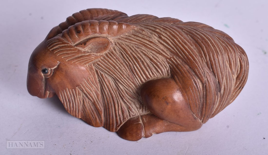 A JAPANESE WOOD GOAT NETSUKE. 4 cm x 3.5 cm. (1 of 4)