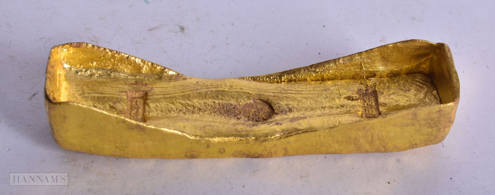 A CHINESE YELLOW METAL SCROLL WEIGHT. 12 cm wide.: A CHINESE YELLOW METAL SCROLL WEIGHT. 12 cm wide.