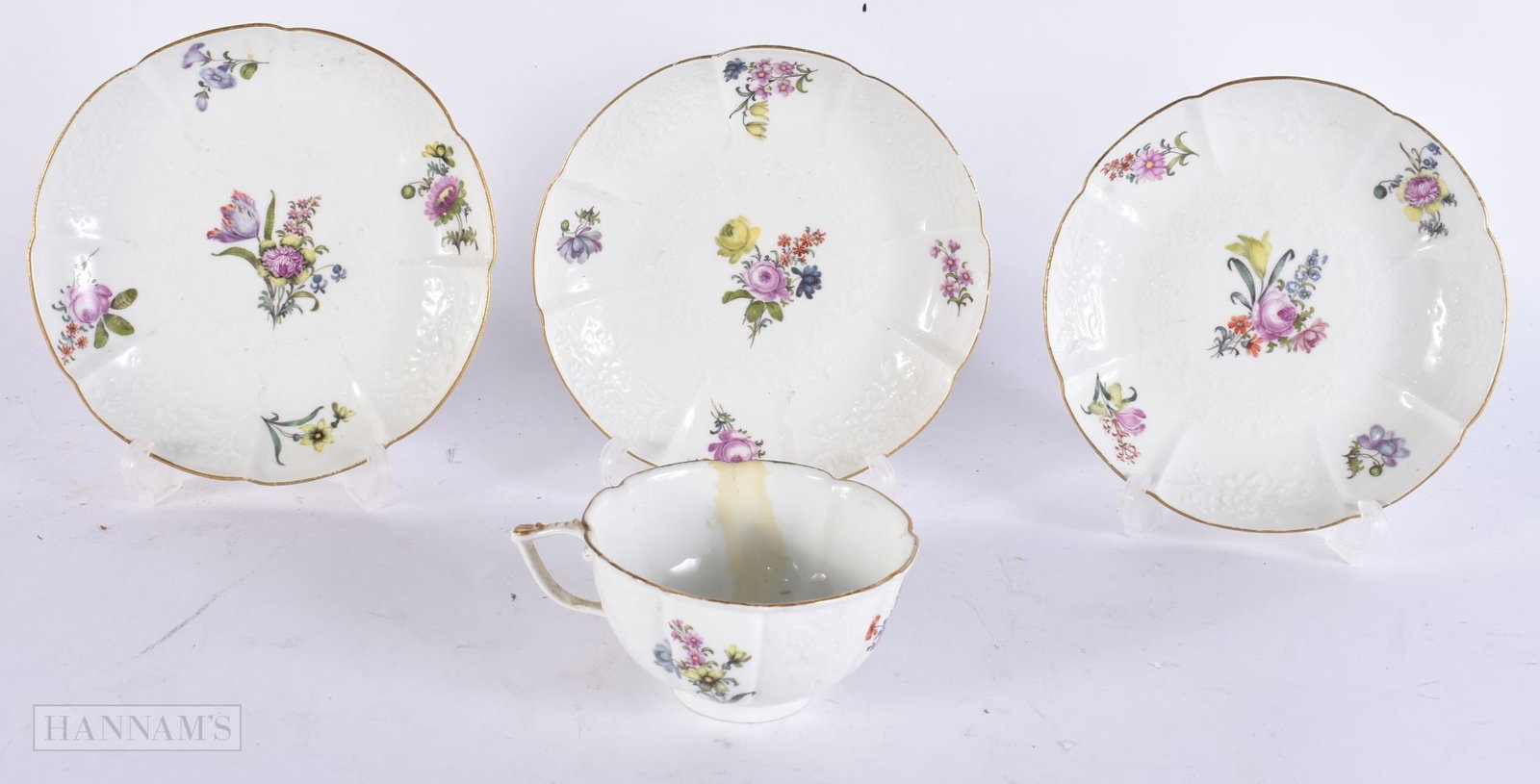 AN ANTIQUE MEISSEN PORCELAIN CUP AND SAUCER together with two other matching saucers. (4) (1 of 4)