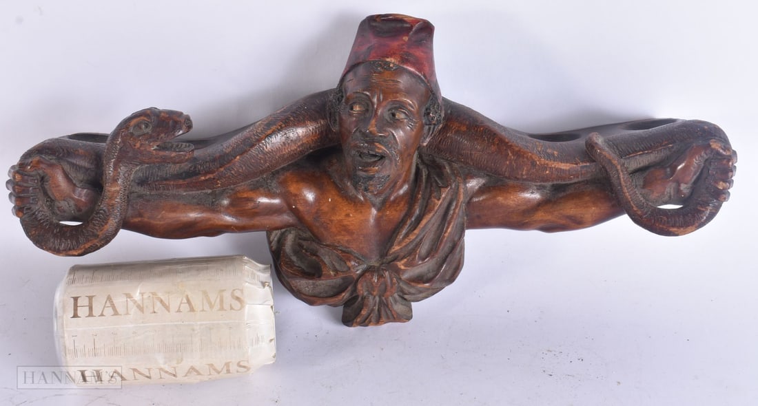 A RARE 19TH CENTURY CARVED WOOD MIDDLE EASTERN DESIGN PIPE RACK depicting a male grappling a snake. (1 of 4)