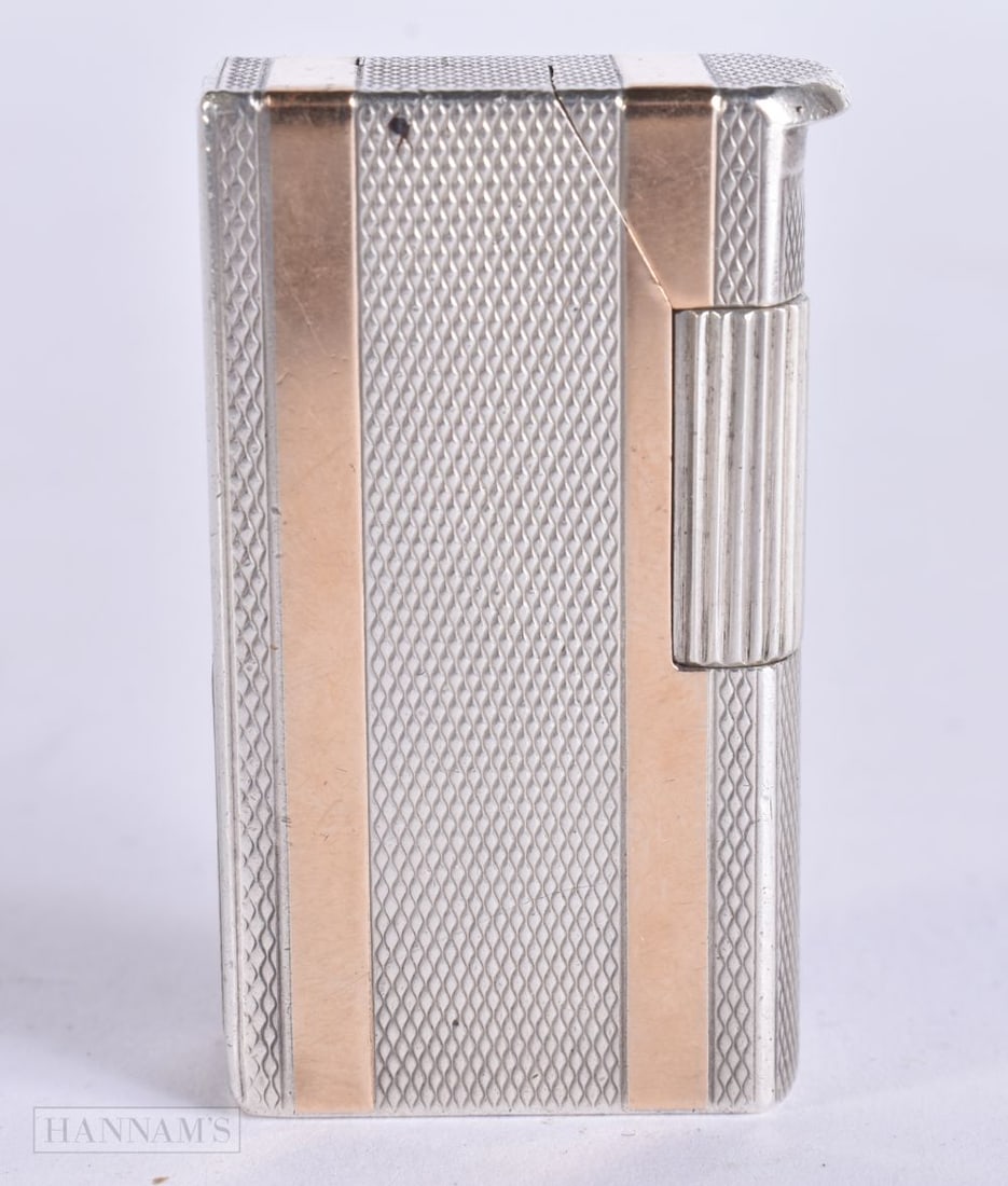A DUNHILL SILVER AND GILT LIGHTER. 4.75 cm high.: A DUNHILL SILVER AND GILT LIGHTER. 4.75 cm high.