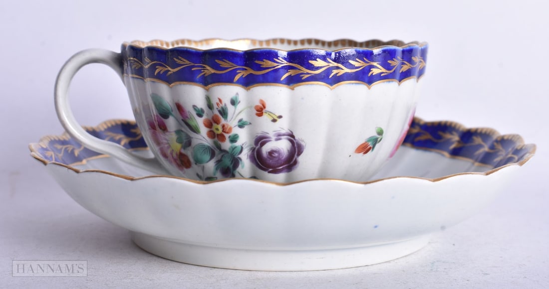 Worcester fluted teacup and saucer painted with flowers around a central wreath,14 cm diameter: Worcester fluted teacup and saucer painted with flowers around a central wreath,14 cm diameter