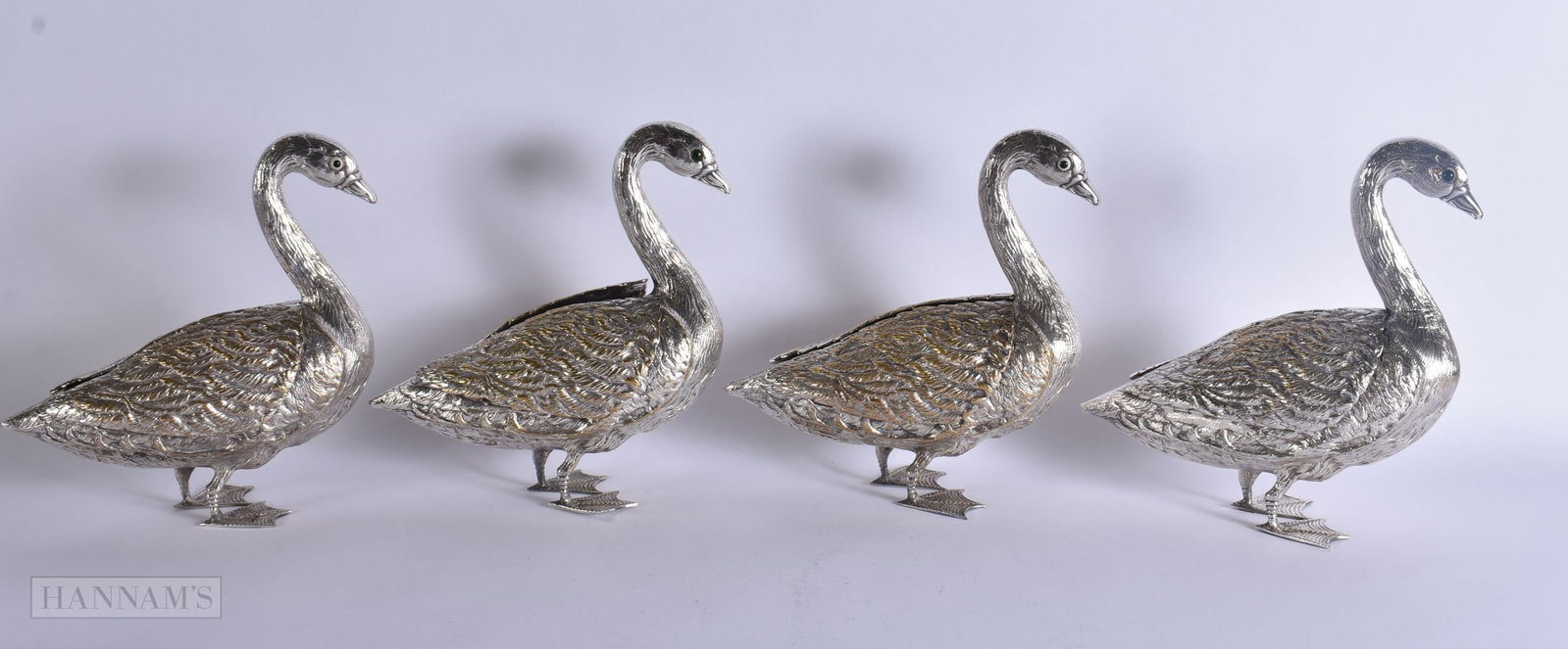 A SET OF FOUR SILVER PLATED FIGURES OF DUCKS with folding weeks revolving a fitted interior. 25 cm x: A SET OF FOUR SILVER PLATED FIGURES OF DUCKS with folding weeks revolving a fitted interior. 25 cm x 18 cm. (4)
