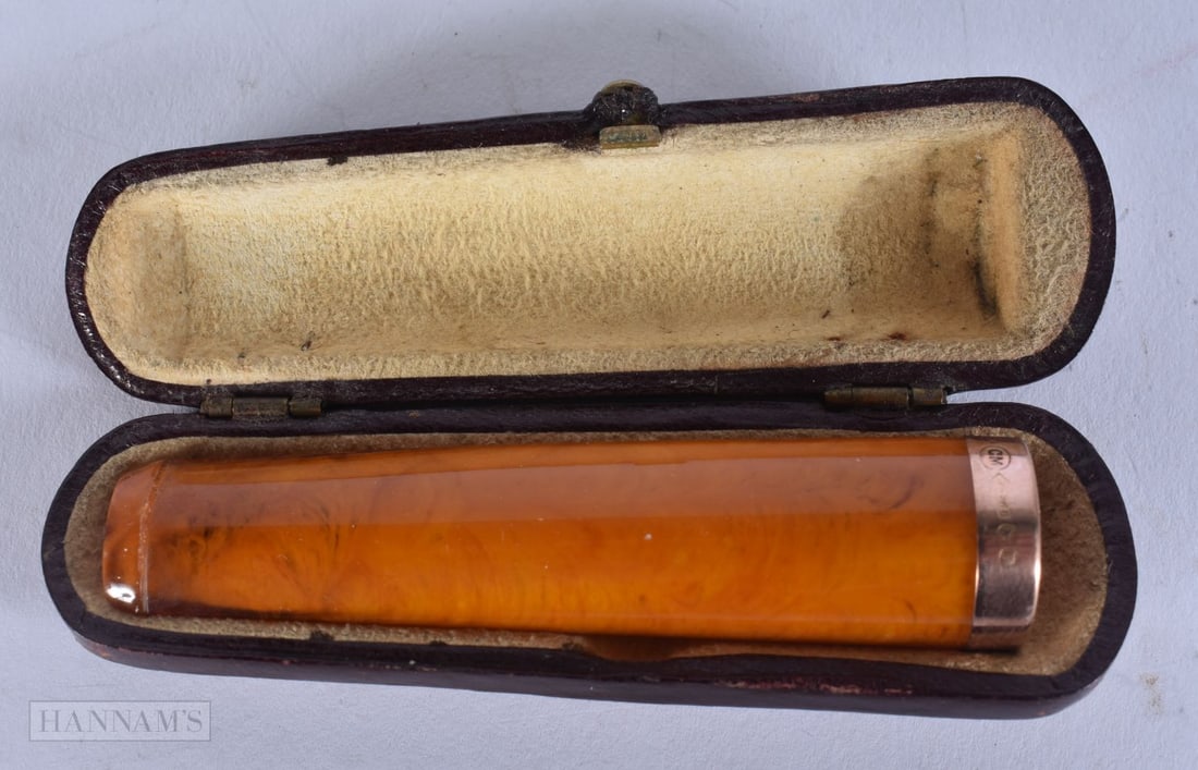 A 9CT GOLD AND AMBER CHEROOT. 8 cm wide.: A 9CT GOLD AND AMBER CHEROOT. 8 cm wide.