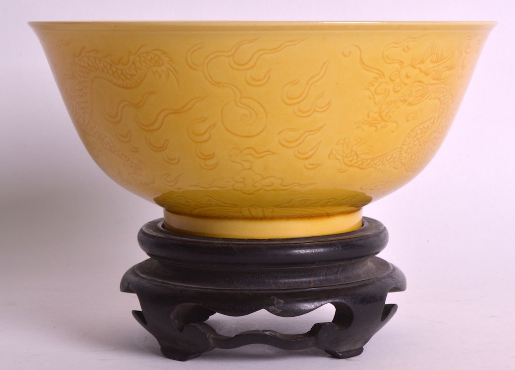 A CHINESE PORCELAIN YELLOW GROUND CIRCULAR BOWL Guangxu: A CHINESE PORCELAIN YELLOW GROUND CIRCULAR BOWL Guangxu mark and possibly of the period, incised with dragons pursuing a flaming pearl. 6ins diameter.