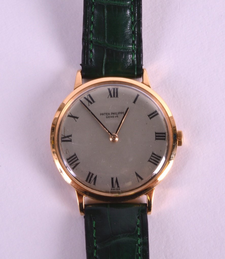 AN 18CT YELLOW GOLD PATEK PHILIPPE SWISS WRISTWATCH the: AN 18CT YELLOW GOLD PATEK PHILIPPE SWISS WRISTWATCH the silvered dial with black painted numerals.