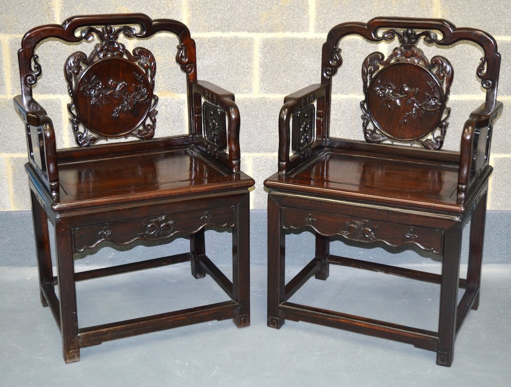 A PAIR OF 19TH CENTURY CHINESE CARVED HARDWOOD: A PAIR OF 19TH CENTURY CHINESE CARVED HARDWOOD ARMCHAIRS carved with panels of birds perched amongst foliage, with floral frieze. £2500-3000