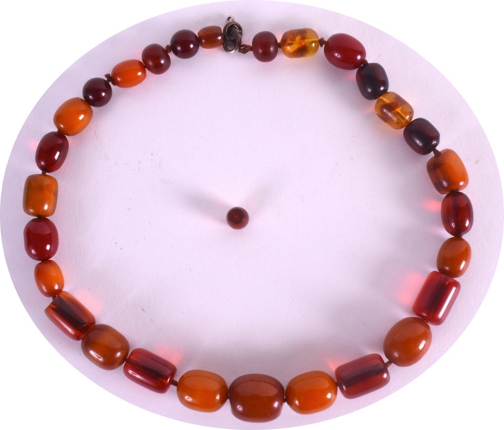 A MID 20TH CENTURY RECONSTITUTED AMBER NECKLACE of: A MID 20TH CENTURY RECONSTITUTED AMBER NECKLACE of various tones. 1ft 10ins long. £20-30