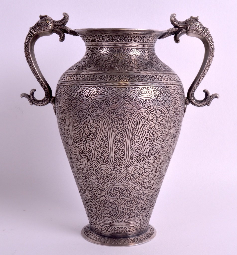 A FINE 19TH CENTURY MIDDLE EASTERN TWIN HANDLED SILVER: A FINE 19TH CENTURY MIDDLE EASTERN TWIN HANDLED SILVER VASE with fish type mounts, engraved all over with extensive foliage and scrolling landscape panels. 7.75ins high.