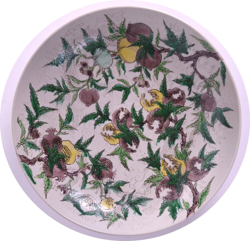 A 19TH CENTIRY CHINESE WHITE GLAZED SANCAI POMEGRANATE: A 19TH CENTIRY CHINESE WHITE GLAZED SANCAI POMEGRANATE DISH bearing Kangxi marks to base, enamelled to front and body with flowering vines, with an under incised trailing dragon. 10ins diameter.