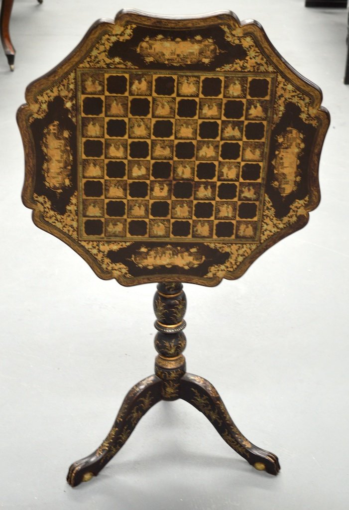 A CHINESE EXPORT QING DYNASTY BLACK LAQUER CHESS TABLE: A CHINESE EXPORT QING DYNASTY BLACK LAQUER CHESS TABLE the top finely decorated with Oriental scenes of figures within landscapes, flanked with gilt foliage, upon a similar base with scrolling foliage