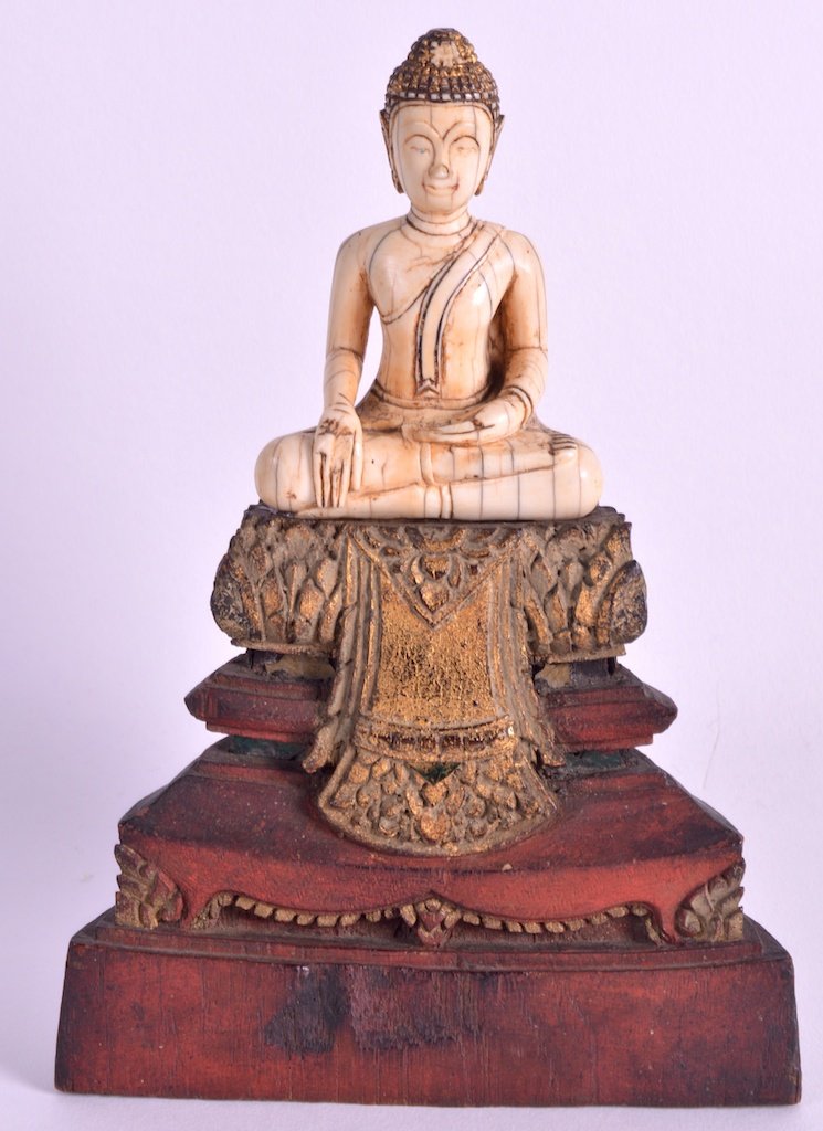 A 17TH/18TH CENTURY SOUTH EAST ASIAN IVORY FIGURE OF A: A 17TH/18TH CENTURY SOUTH EAST ASIAN IVORY FIGURE OF A BUDDHA probably Thai, supported upon a later carved giltwood triangular base. Ivory 3.5ins high. £600-800.