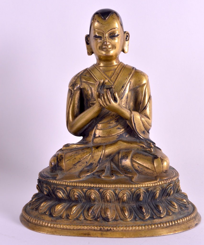 A GOOD 18TH/19TH CENTURY SINO TIBETAN GILT BRONZE: A GOOD 18TH/19TH CENTURY SINO TIBETAN GILT BRONZE FIGURE OF TSONGKHAPA with partially enamelled head, upon a triangular lotus capped base.6.25ins high. £600-800.