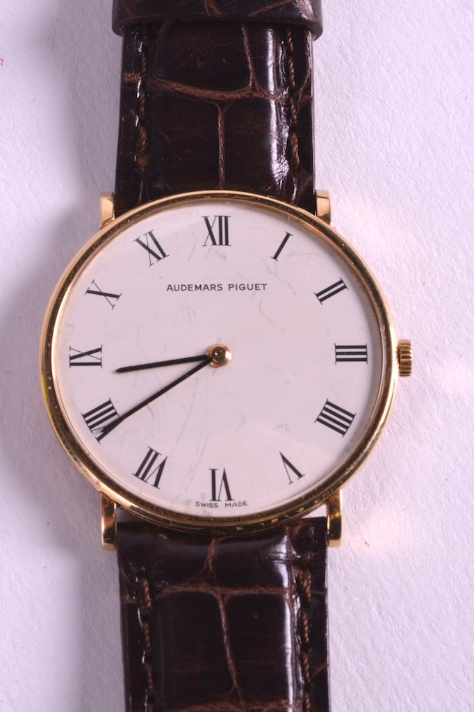 AN 18CT YELLOW GOLD GENTLEMANS AUDEMARS PIGUET: AN 18CT YELLOW GOLD GENTLEMANS AUDEMARS PIGUET WRISTWATCH with brown leather strap and gold cased dial. 1.25ins diameter.