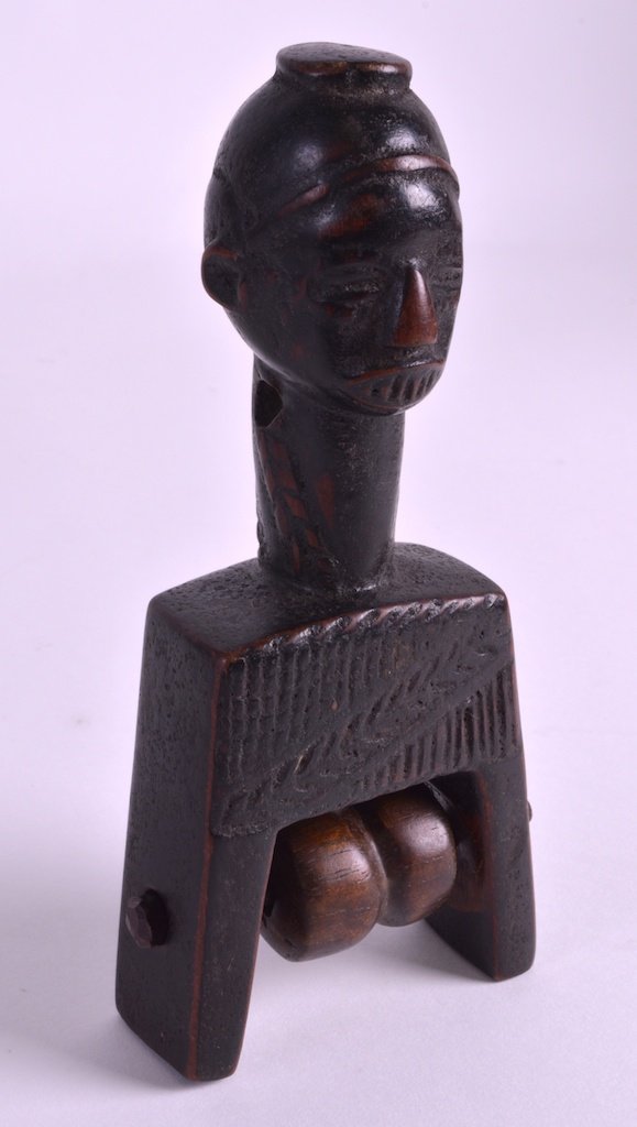 AN EARLY 20TH CENTURY WEST AFRICAN TRIBAL PULLEY with: AN EARLY 20TH CENTURY WEST AFRICAN TRIBAL PULLEY with revolving central section, of figural form. 6.25ins high.